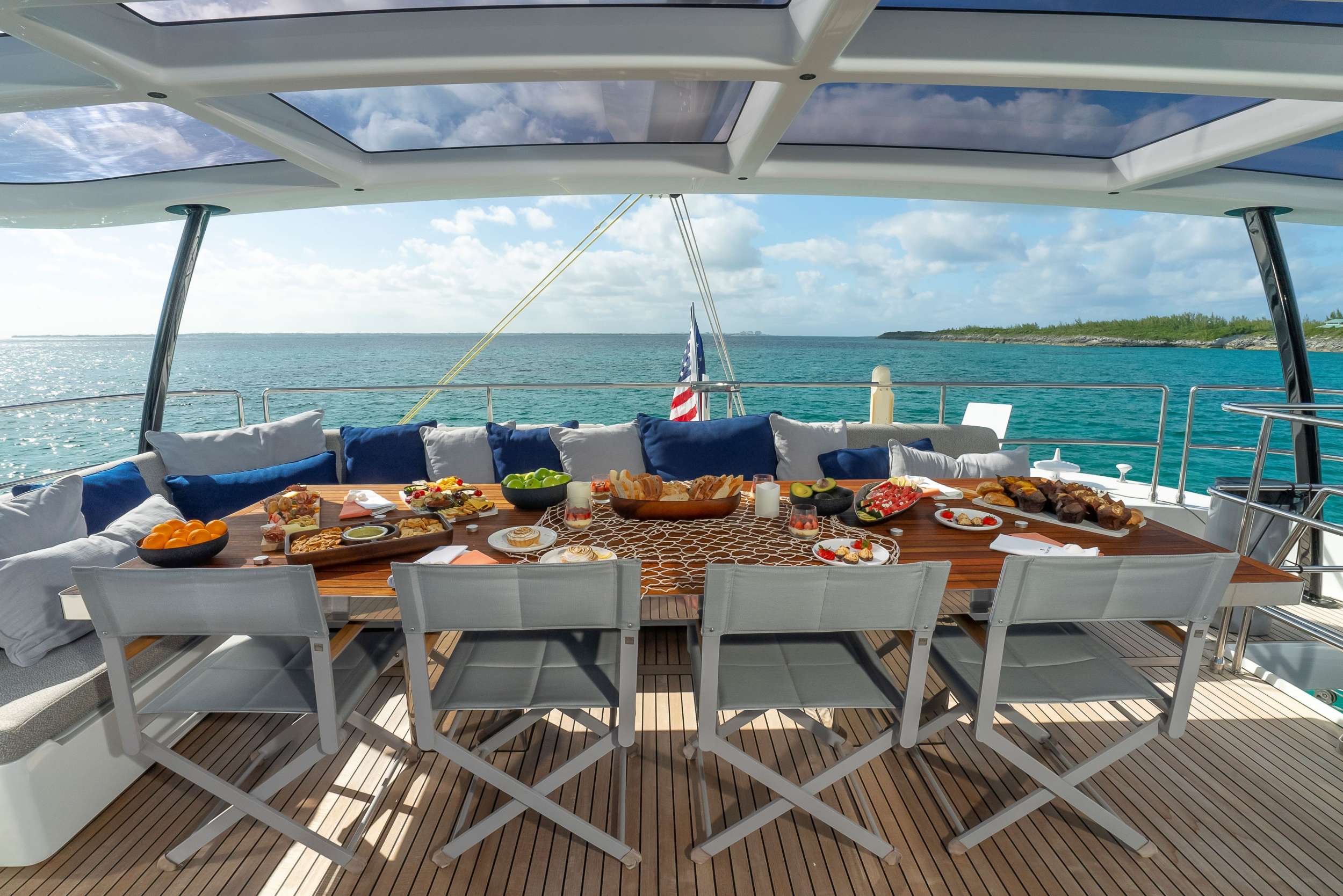 Flybridge dining with a long table and sea view